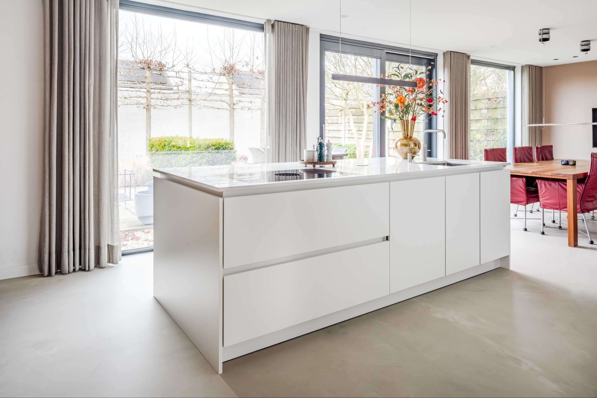 lavasteen-vloer-smitfloor-geldrop---witte-keuken-in-een-ruime-woonkamer