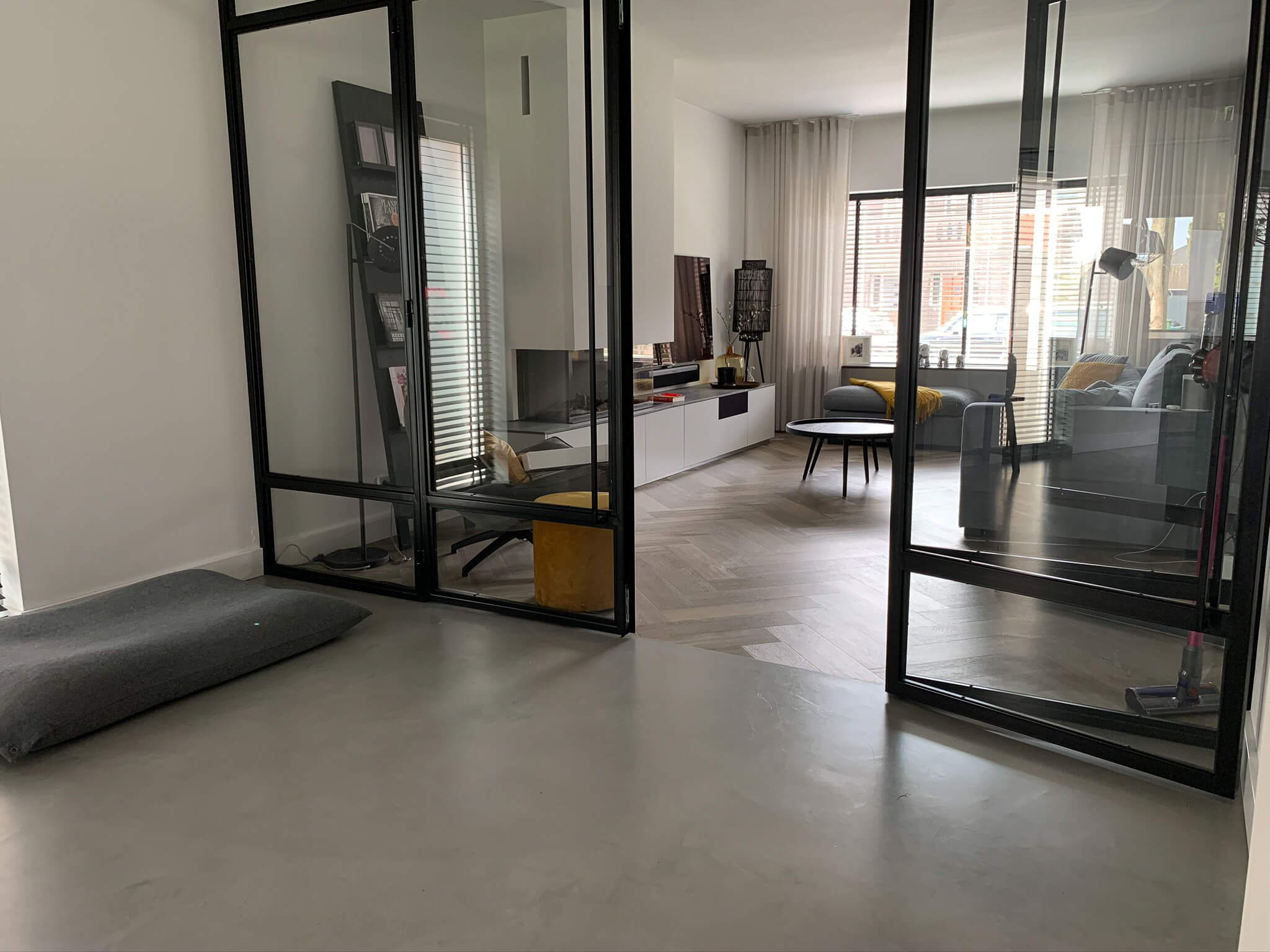 betonlook-gietvloer-smitfloor-geldrop---industrieele-vloer-voor-een-ruimte-met-stalen-deuren-en-wit-kookeiland